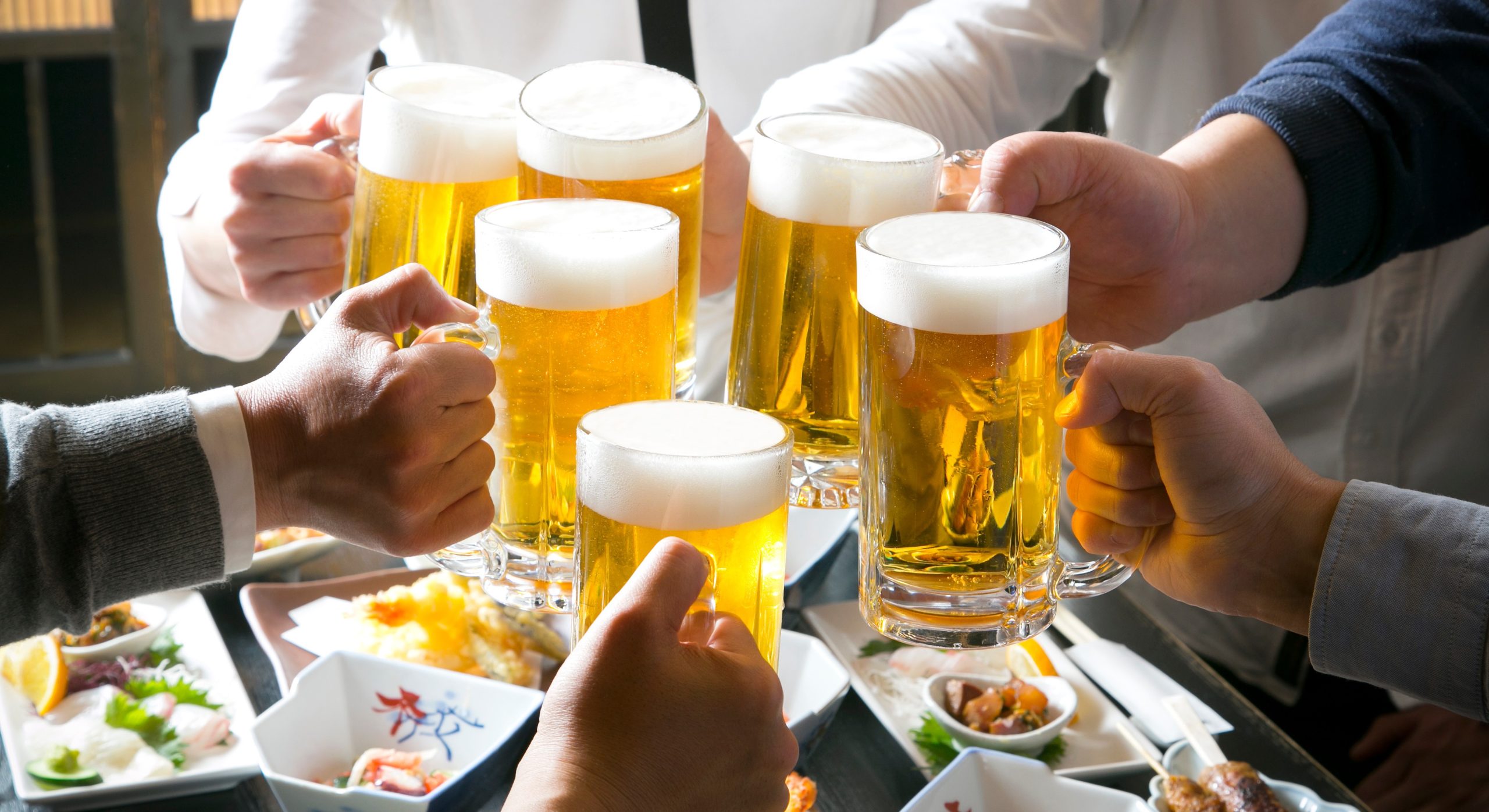居酒屋でビールで乾杯をする６人